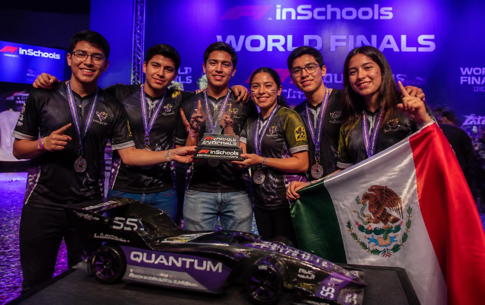 Escudería mexicana celebrando con su trofeo y su auto a escala en una final internacional
